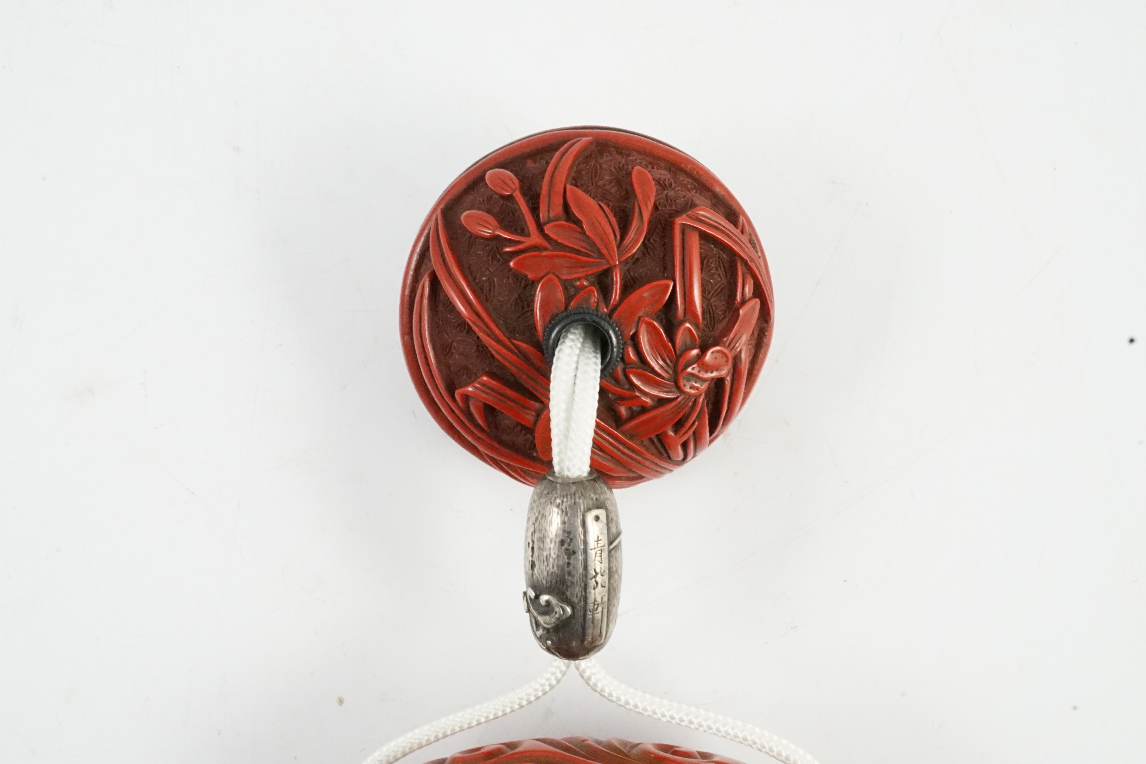 A good Japanese tsuishu (carved red lacquer) four case inro, by Yosei, and a similar manju netsuke, 19th century